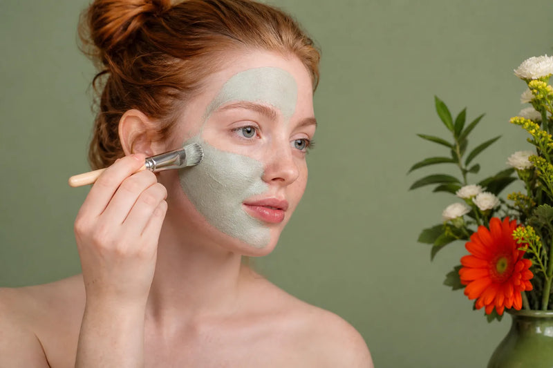 Woman with very fair skin applying a face mask