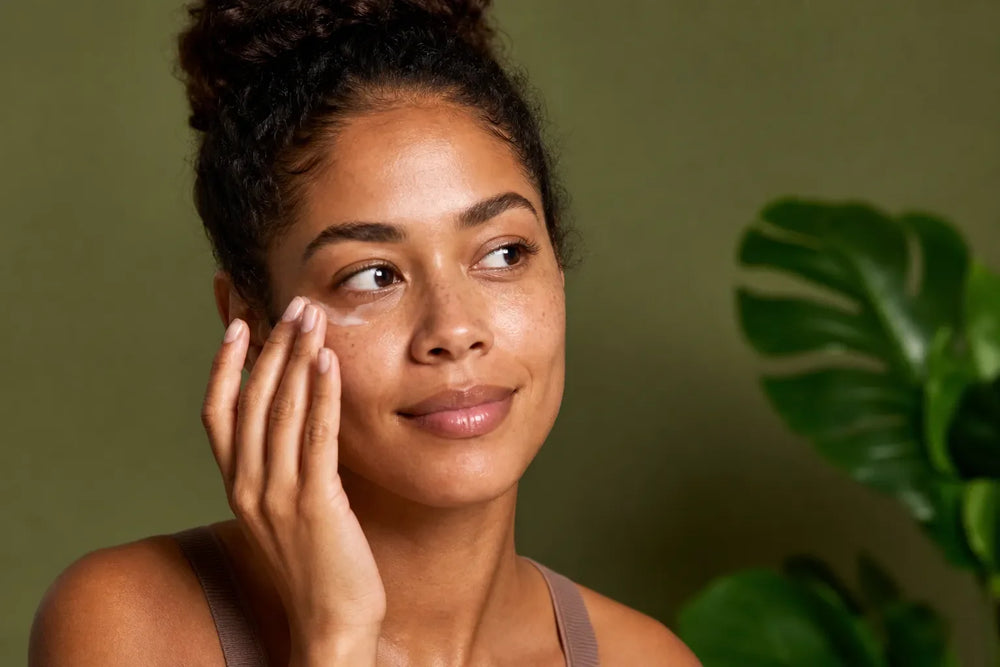 Woman with warm brown skin applying eye cream