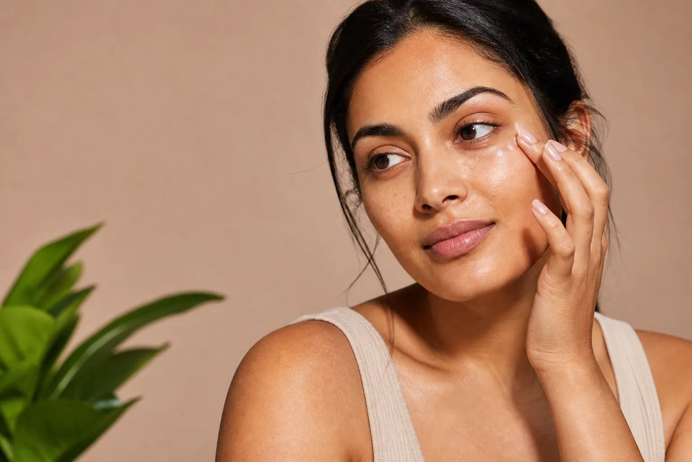 Woman with medium olive skin applying eye cream