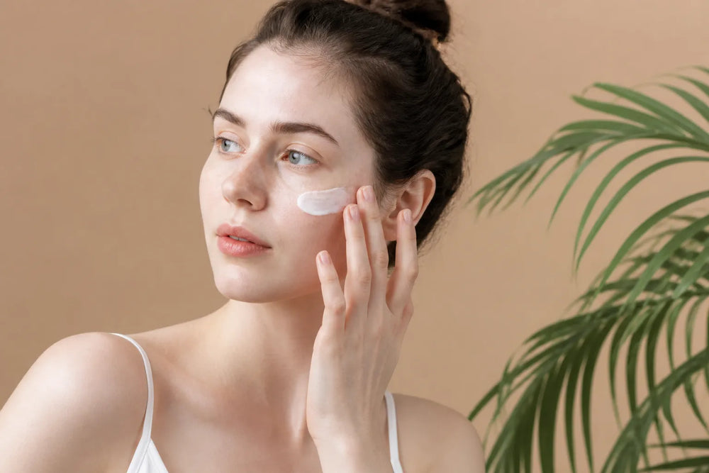 Woman with very fair skin applying sunscreen