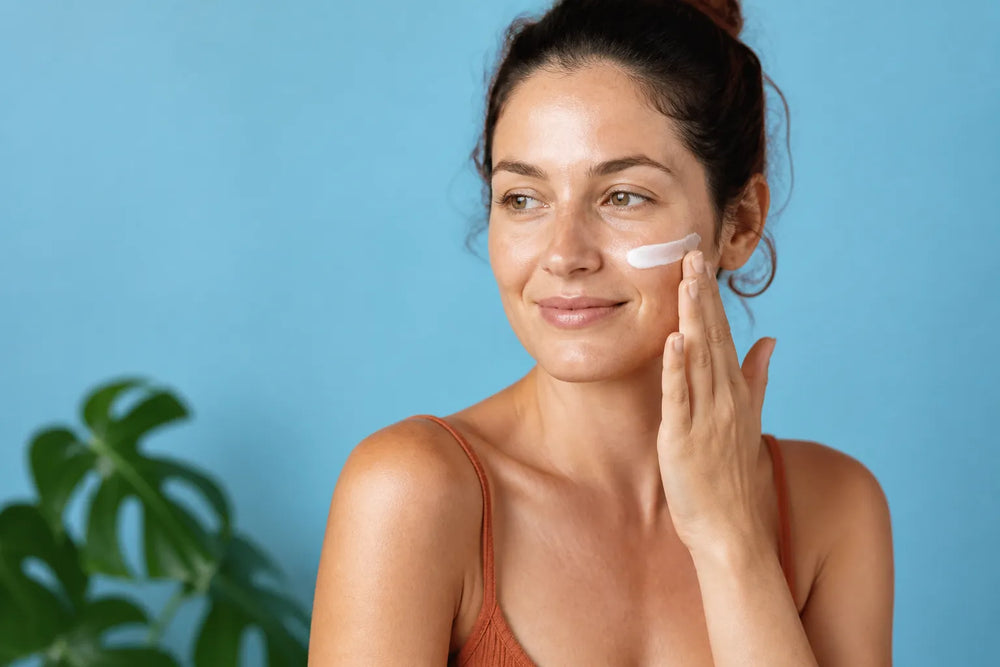 Woman with light skin applying sunscreen