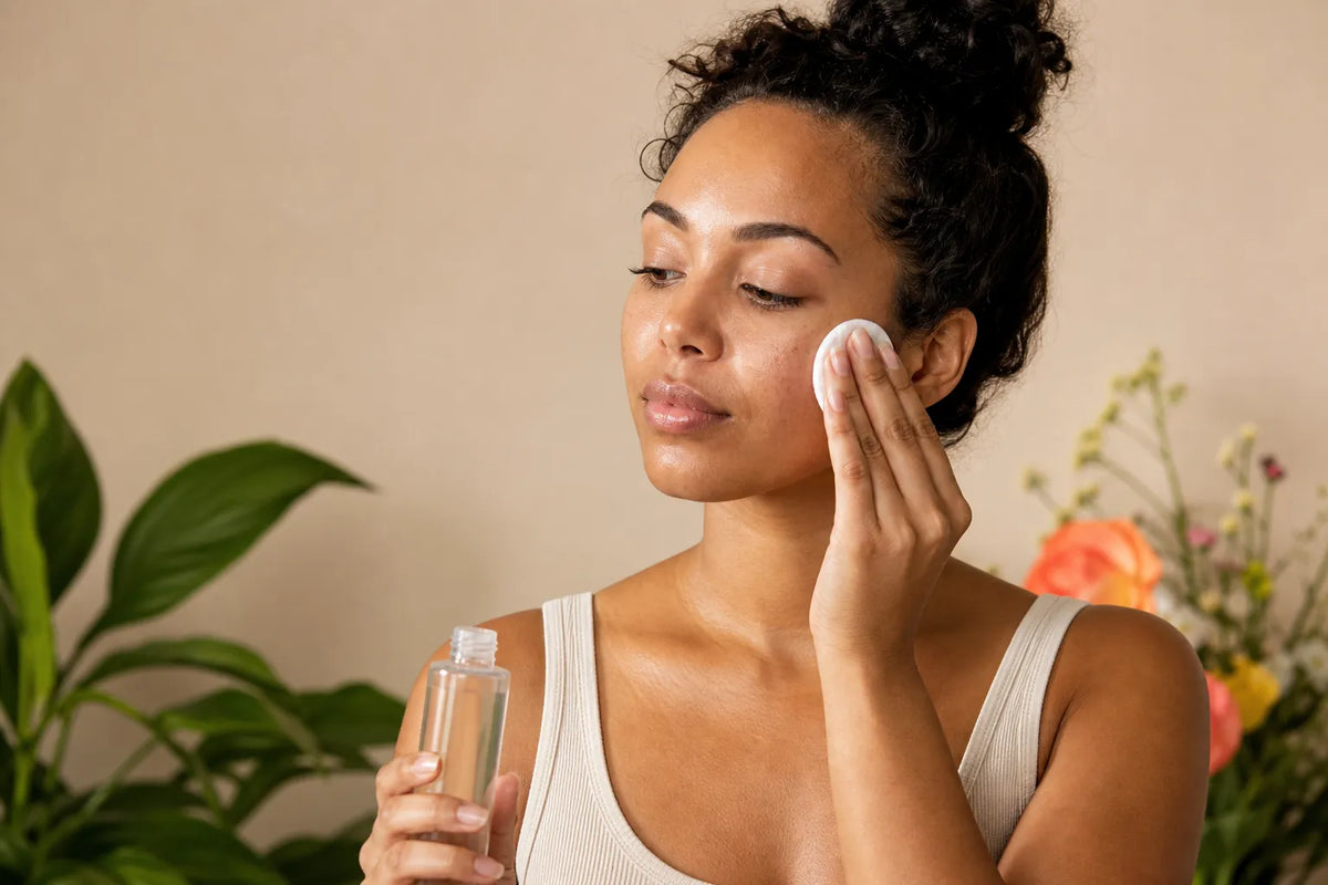 Woman with warm brown skin applying toner