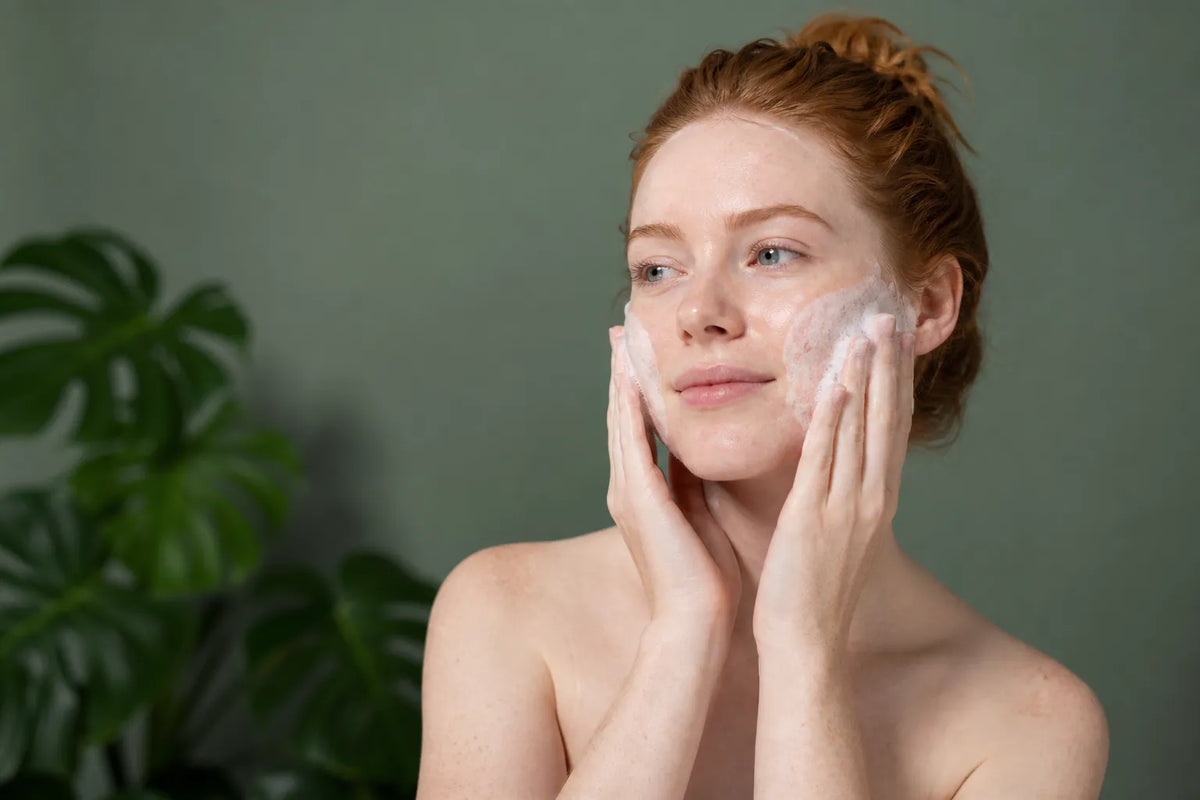 Woman with very fair skin cleansing her face