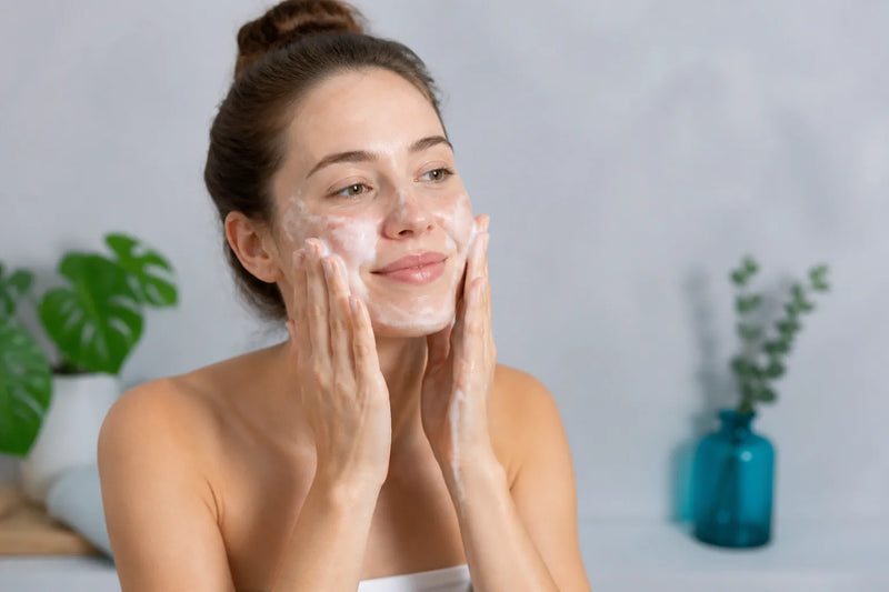 Woman with light skin washing her face